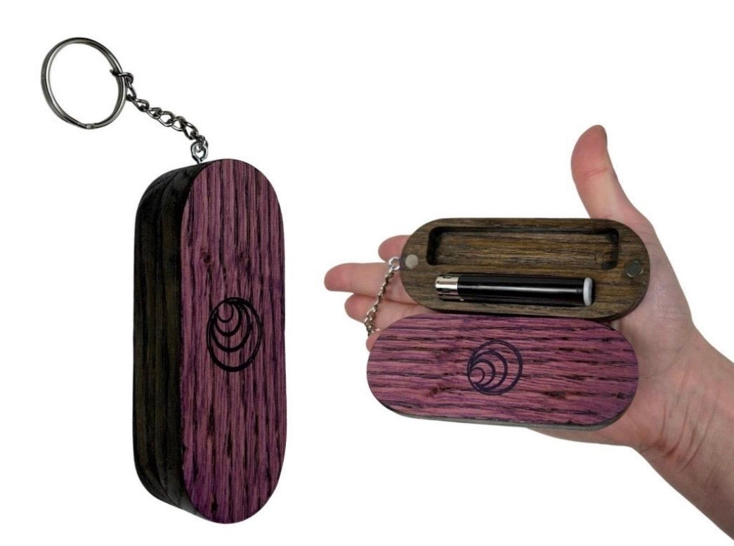 Wooden keychain with purple finish and black logo held by a hand on a white background
