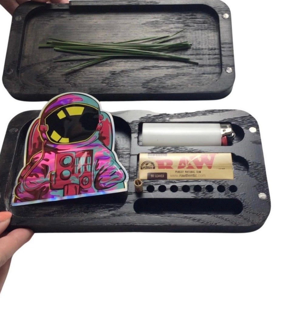 Black rolling tray with rolling accessories including a colorful rolling paper holder and RAW branded items.