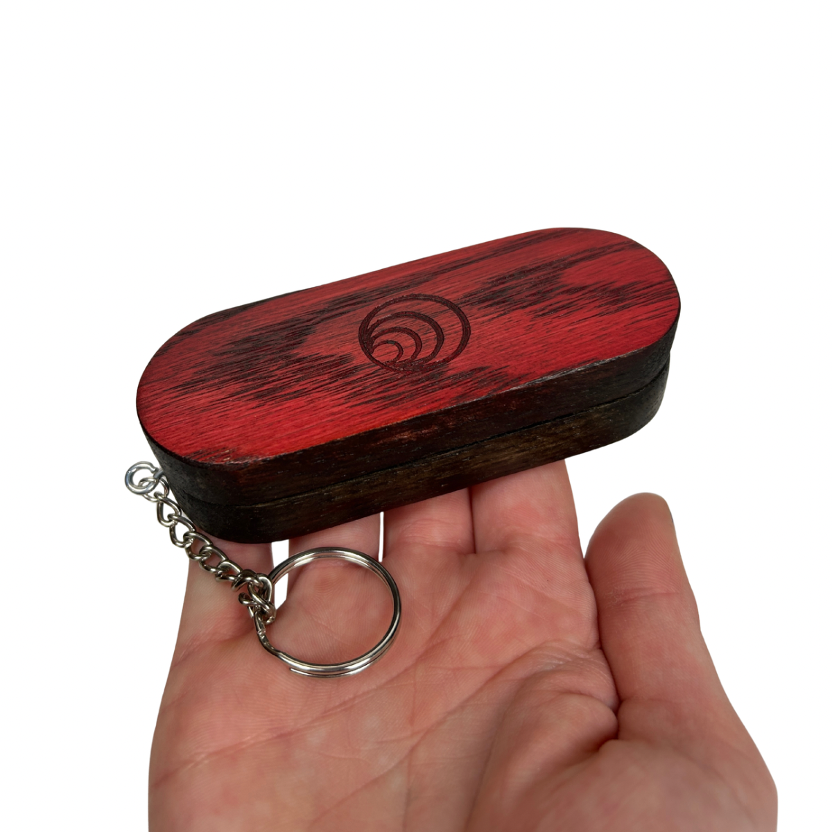 Wooden key case with keychain held in a hand on a white background