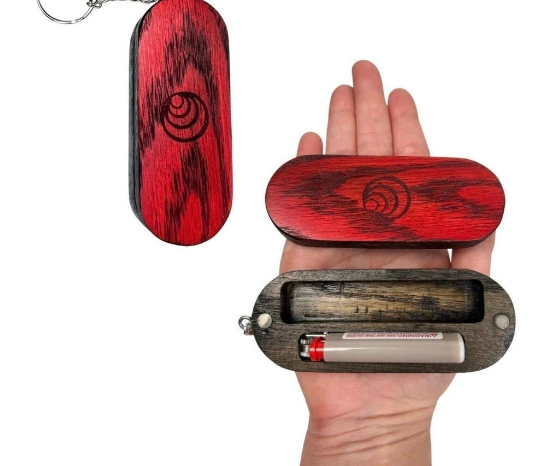 Red wooden keychain with spiral design held in a hand, showing its size.