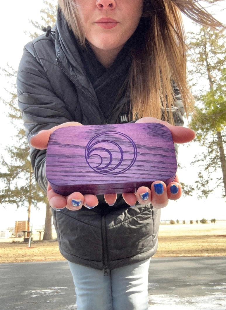 Person holding a purple cigar case with lighter inside.