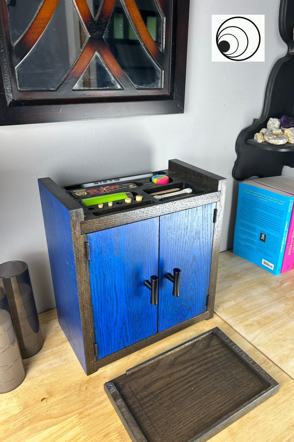 Blue wooden cabinet with tools on a wooden floor next to a colorful locker.
